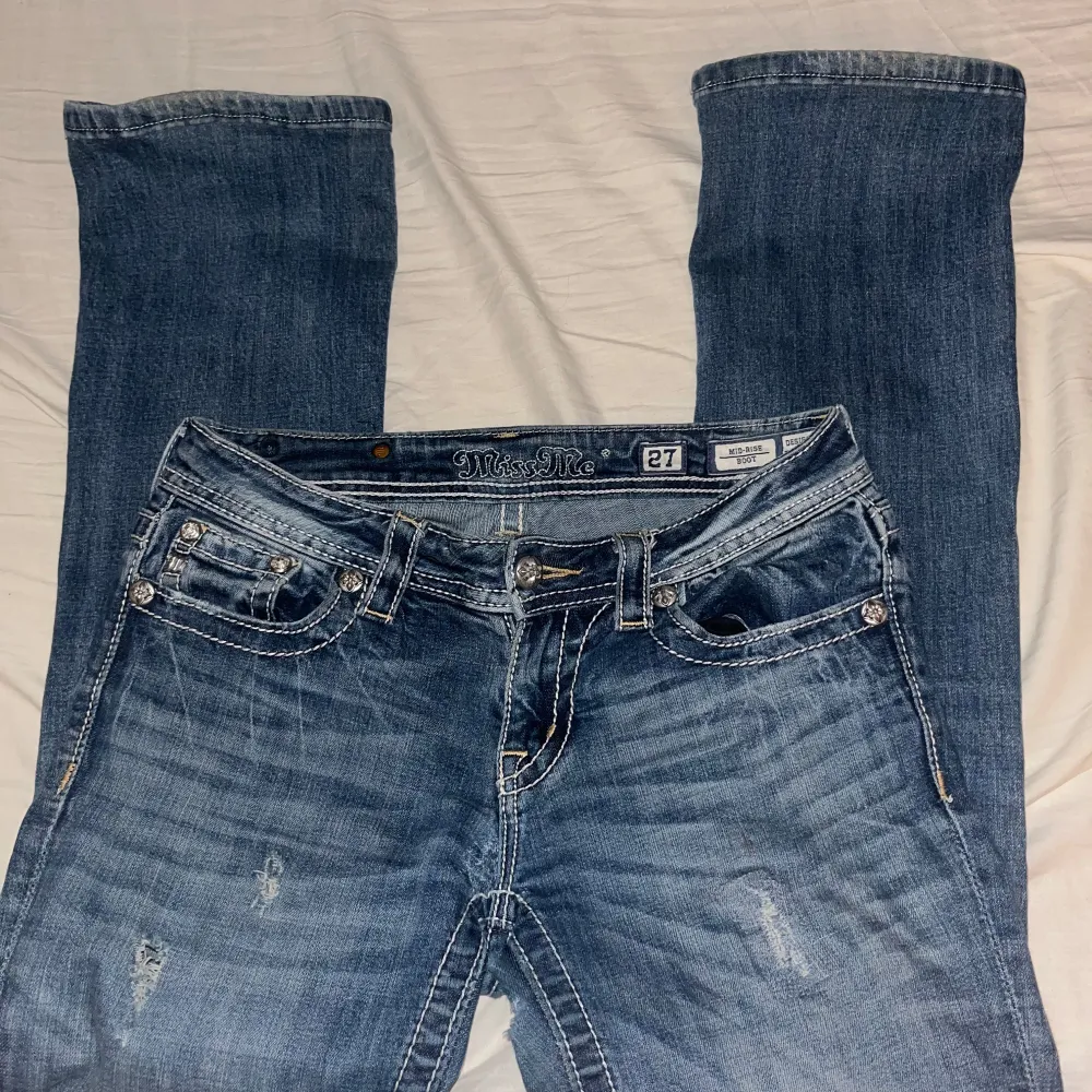 Snygga blå jeans från Miss Me med broderade bakfickor i ett detaljerat mönster. Har dock ett hål vid innerlåret som inte syns . Har också tappat knappar på flärpen. Farkut & Housut.