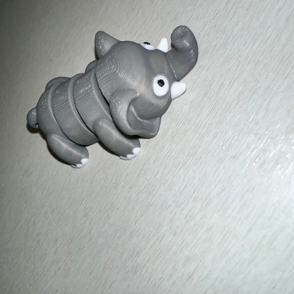 Charmig grå elefantfigur skapad med 3D-printing. Den har en segmenterad kropp som ger den en flexibel och lekfull design. Perfekt som dekoration eller leksak.. Böcker.