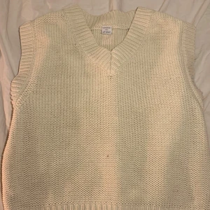 Vit stickad väst från Lindex - Säljer en stilren vit stickad väst från Lindex i storlek 158/164. Västen har en klassisk v-ringning och är perfekt för lager-på-lager-stil. Den är mjuk och bekväm, idealisk för både vardag och speciella tillfällen. Passar perfekt för den som gillar en tidlös look.