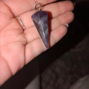 Ametist pendel - Säljer en vacker lila pendel i Ametist perfekt för meditation eller som ett unikt smycke. Den har en konisk form och hänger i en kedja. Perfekt för dig som älskar kristaller och andlighet.