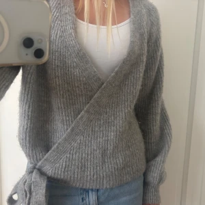 Grå omlottkofta från ONLY XS - Mysig grå ribbstickad omlottkofta från ONLY i storlek XS. Koftan har knyt i sidan, djup v-ringning och långa ärmar. Fint skick! Säljer till bra pris för att jag vill bli av med den!💛