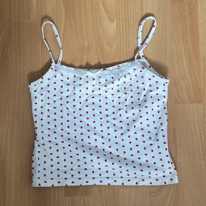 Pyjamas linne Gina Tricot  - Vitt pyjamas linne från Gina Tricot med röda hjärtan,spets detaljer upptill och utan justerbara axelband. Kan användas som vanlig tröja med. Köparen står för frakt.