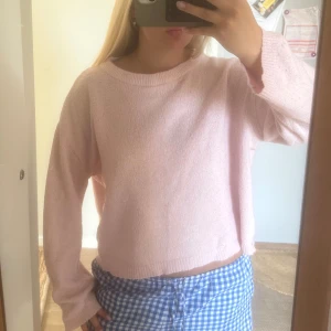 Ljusrosa stickad tröja med loose fit - Supermysig ljusrosa stickad tröja med avslappnad, loose passform och långa ärmar. Tröjan har en enkel rund halsringning och är perfekt för dig som gillar en chill och söt stil. Passar lika bra till jeans som till kjol.