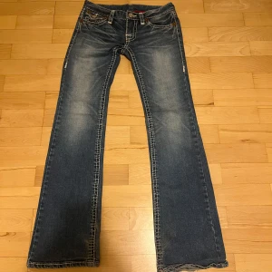 True religion jeans - Lågmidjade blåa True Religion jeans i skorlek 26. De är lite ljusare i verkligheten än på bild. Mycket bra skick förutom lite slitage längst ner. Midjemått tvärs över: 35cm Innerbanslängd: 78cm Bootcut bredd: 22cm