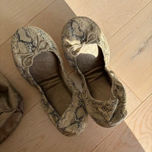 Ballerinaskor i snakeskin - Ballerinaskor från Gap i ormmönstrat skinn (äkta läder) med rund tå och rosett framtill. Skorna har platt sula och följer med en matchande påse, vikbara. 💓