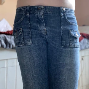 Utsvängda jeans med låg midja - Lågmidjade jeans med lite utsvängda ben, från United colors of benetton. Storleken uppskattar jag till S/M, eftersom det inte står någon storlek i byxorna. (kanske även XS om man använder knappen längre in, se bild 4). På bild fyra syns den extra knappen som redan fanns där när jag köpte dem second hand, vilket gör att man kan få dem att sitta lite tajtare. Byxorna är väl använda, men inte trasiga och fortfarande i fint skick. Pris går att diskutera!🙌🏻🙌🏻  Jag föredrar att posta via PostNord.