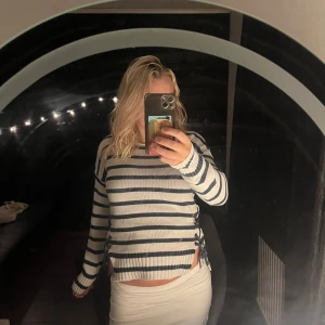 Randig stickad tröja med rosetter - Superfin stickad vit tröja med marinblå ränder! Tröjan har två slitsar på vardera sida och även snygga knytrosetter som ger en unik touch. Perfekt och snygg tröja  till alla tillfällen! Storleken är 146/152 men passar superbra till mig som har S i storlek annars!💞💞