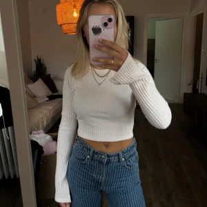 Ljusrosa ribbad croppad tröja - Ljusrosa croppad tröja med ribbad struktur och långa ärmar med öppning 