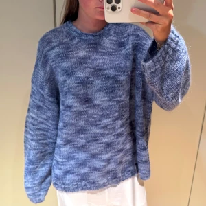Blå stickad oversized tröja - Supermysig stickad tröja i blåmelerat garn med breda, långa ärmar och avslappnad oversized passform. Har använts fåtalgånger !!