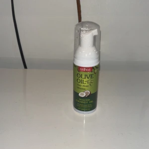 Grön mousseflaska med pump (olive oil) - En mousseflaska med vit pump och genomskinligt lock. Flaskan är grön med text på etiketten. Produkten är i plast och har en smidig design som passar bra i necessären. Perfekt för dig som gillar praktiska och snygga förpackningar.