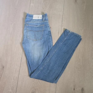 Tiger of Sweden Jeans - Snygga ljusblå skinny jeans från Tiger of Sweden med klassisk femficksdesign och diskreta slitningar framtill. Jeansen har normal midja och raka bakfickor med kontrastsömmar. Perfekta för en clean och stilren look. Passar till många olika stilar. Storlek 30/34
