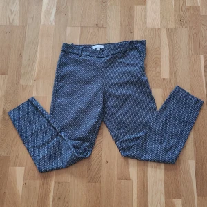 Mönstrade kostymbyxor från H&M - Snygga kostymbyxor från H&M i storlek 36. Byxorna har raka ben, bälteshällor och diskreta fejk bakfickor. 