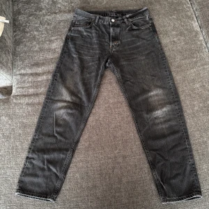 Grå tapered jeans från Weekday 29/30 - Säljer ett par grå jeans från Weekday i modellen Barrel Relaxed Tapered. Jeansen har en avslappnad passform upptill och smalnar av nedtill, klassisk femficksdesign och lite orangea sömmar som detalj. Perfekta för dig som gillar en chill men snygg look.