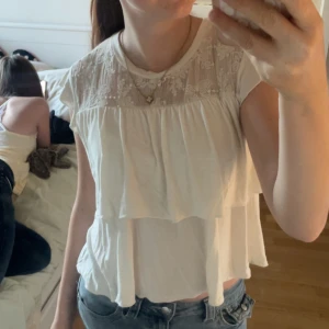 Vit blus med spets och volanger - Supersöt vit blus med volanger och spets upptill. Använd fåtal gånger. Storlek 146/152 men passar mig som är 160. 🤍