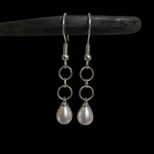 Silverörhängen med pärldroppar stockholmstil - Snygga örhängen i silverfärg med kedjor av ringar och droppformade vita pärlor längst ner. De har en modern och stilren design som ger en cool touch till din look.