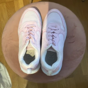 Ljusrosa sneakers från Kappa - Snygga ljusrosa sneakers från Kappa med vit sula. Skorna har mesh- och syntetpaneler, klassisk snörning och rund tå. Perfekta för dig som vill ha en sportig och fräsch look med en feminin touch.