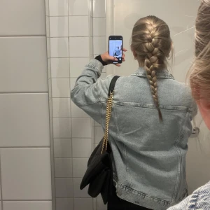 Oversized ljusblå jeansjacka - Säljer en oversized ljusblå jeansjacka med klassiska sömmar och bröstfickor. Jackan har en avslappnad passform och är perfekt att slänga över en klänning eller hoodie. Den är tillverkad i denim och har knappar framtill. Superenkel att styla för en chill look.