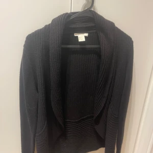 Svart ribbad kofta från H&M - Svart ribbstickad kofta från H&M i storlek S😊Koftan har en öppen front utan knappar och bred krage, perfekt basic plagg. Tjockare stickning nertill och vid kragen ger en snygg kontrast!💕💕