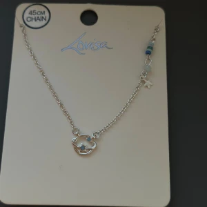 Silvrigt halsband med planet och stjärna Lovisa - Skickar iväg samma dag eller dagen efter🙌🏼 Snyggt halsband från Lovisa i silverfärg med en 45 cm kedja. Hänget är format som en planet med små stjärnor och en extra liten stjärnberlock samt blå och gröna pärldetaljer på kedjan. Perfekt för dig som gillar rymdtema och unika smycken.