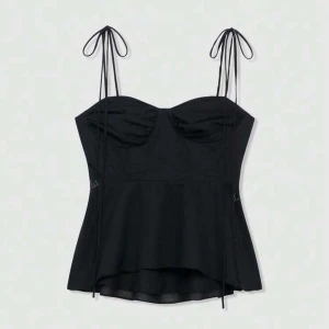 Svart topp med knytband - Supersnygg svart korsettopp från shein med tunna axelband som knyts upptill.  Den är identiskt till den som Zara har. Den är figurnära upptill och faller snyggt nedtill. Perfekt för dig som gillar trendiga detaljer och stilren look. Den är storlek M, men var tyvärr för liten för mig💗så skulle mer säga att den är en xs-s