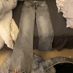 Gråa raka bootcut jeans med design på baksidan  - Aäljer ett par gråa jeans med speciell design på dragkedjan och baksidan dem är i strl xxs short model och passar även xs byxorna är som nya