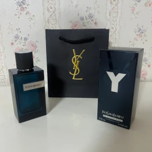 Yves Saint Laurent Y EdP Intense 100ml - Yves Saint Laurent Y Eau de Parfum Intense, 100 ml. Flaskan är mörkblå med silverdetaljer och svart texturerad kork. Kommer med originalkartong och elegant svart YSL-påse med guldfärgad logga. En modern och stilren parfymflaska i glas.