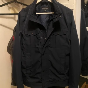 Mörkblå field jacket från J.Lindeberg - Vid snabb affär kan priset diskuteras! Snygg mörkblå field jacket från J.Lindeberg. Använd 1 gång, säljer då den inte kommit till användning. Storlek S, men kan passa M. Perfekt jacka till sommarkvällar. Ordinarie pris:3400.                                      