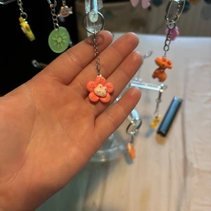 Söt rosa blomörhänge med pärldetalj - Unikt örhänge med en handgjord blomma i rosa och vitt, hängande på en silverfärgad kedja. Blomman har en söt pärldetalj i mitten och lekfull design som sticker ut. Perfekt accessoar för dig som gillar färg och roliga former.
