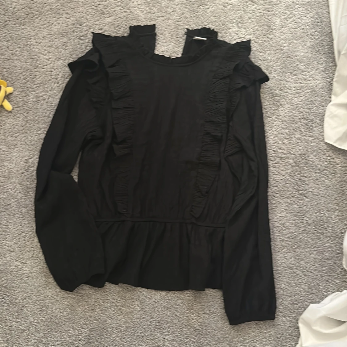 Svart blus med volangdetaljer