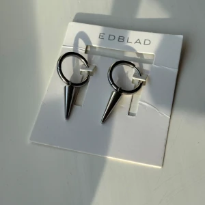 Edblad Peak Hoops örhängen i stål - Snygga örhängen från Edblad i modellen Peak Hoops Steel. De är i blankt silverfärgat stål med coola konformade hängen som ger en edgy vibe. Perfekta hoops för dig som gillar minimalistisk men ändå tuff stil. De är använda ett par gånger, alltså kommer jag dra ner priset till 249kr. Skriv om ni har några funderingar eller vill ha fler bilder på varan.