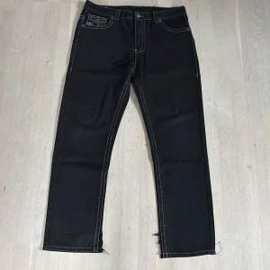 Svarta True Religion Fat Stitch jeans - Svarta jeans från true religion med fat stitch. Svarta med grå stitching fire ash rare u aint finding. Skriv om frågor eller bilder säljer pga att snabba pengar behövs och kommer inte till använding.🙏Inre benet är klippt i botten så att det ska sitta bättre över skor se bild 3. Strlk 38 men kan passa vem som me bälte och är fof fire🙏