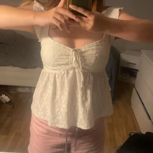 Vit blommig blus  - Supersöt vit blus med små blommor i spets och knyt framtill, den är använd 2 gånger så i super bra skick. Kom privat vid fler bilder och bilder !!priset diskuteras vid snabb affär!!