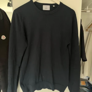 Mörkblå tröja från Bläck - En stilren mörkblå tröja från Bläck i storlek S. Tröjan har rund halsringning, ribbade muddar och är långärmad. Perfekt att matcha med jeans eller under en väst m.m för en clean look. (Se sista bilden för outfit inspiration) pris kan diskuteras 