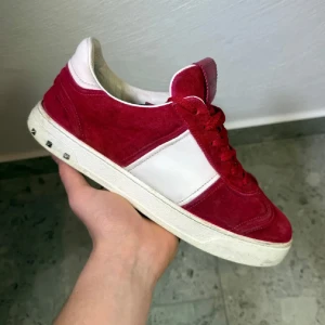 Röda Valentino Flycrew  - Röda Valentino Flycrew || Storlek 40, innermått 26,5cm (passar ca 41) || Skorna är i okej skick, mockan är fläckig samt så är sulan något rosa från mockan || Mitt pris 2999 || 6 nitar är av, vid köp medföljer reservnitar (ej orginal) || Tveka inte på att höra av dig vid frågor eller funderingar 