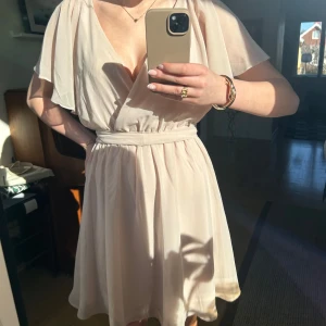 Ljusrosa klänning från Goddiva - Superfin ljusrosa/smutsrosa klänning från Goddiva. En v-ringad design med korta ärmar. Den har knytning i midjan, men super fin utan knytningen också. Endast använd en gång. Perfekt för alla kommande stundentmotagningar, eller midsommarfiranden. Pris kan även diskuteras!