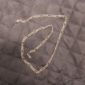 Silver halsband - Snyggtt silver halsband med klassisk kedjedesign. Perfekt för att ge en elegant touch till din outfit. Halsbandet har en säker låsning och är lätt att bära.