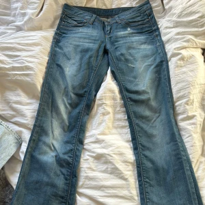 Blå jeans från ONLY - Snygga blå jeans från ONLY med en klassisk femficksdesign och lätt slitna detaljer. De har en bekväm passform och är perfekta för en avslappnad stil. Jeansen har en knapp och dragkedja framtill. Lite slitning på ena benet längst ner. Se bild