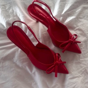 Röda klackar med rosett - Fina oanvända röda klackar. De är stretchiga i hälen. Köpta på en butik i Spanien.