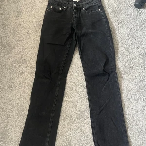 Svarta lågmidjade jeansbyxor XXS - Snygga svarta lågmidjade jeansbyxor med klassisk femficksdesign och knappgylf. De har en rak passform och är perfekta för en stilren look. Passar till många olika outfits och tillfällen. Från lager 157 i storlek XXS 