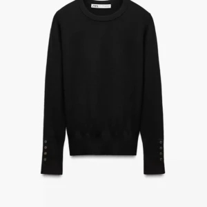 Svart stickad tröja med knappar - Snygg svart stickad tröja med långa ärmar och dekorativa knappar längs ärmarna. säljer då den aldrig används!❤️