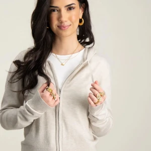 Beige hoodie med dragkedja - Snygg och bekväm beige hoodie med dragkedja framtill. Perfekt för en avslappnad stil. Den har långa ärmar och ribbade muddar vid ärmslut och nederkant.