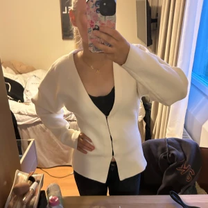Vit kofta - Säljer en stilren vit kofta. Använd 1 gång! Den har en v-ringad design och långa ärmar, figur sydd. Passar bra till både jeans och kjol. Pris går att diskutera. 