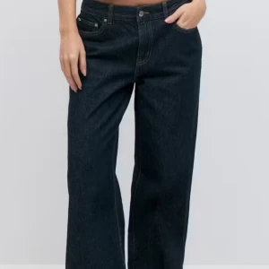 Mörkblå lågmidjade jeans - Snygga mörkblå jeans med en vid passform och hög midja. Perfekta för en avslappnad stil. Klassisk femficksdesign och knappgylf. Från Gina och använda en gång. Storlek 36