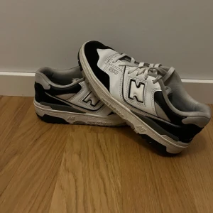 Svartvita sneakers från New Balance - Snygga svartvita sneakers från New Balance med klassisk design. Skorna har snörning och en bekväm passform, perfekt för vardagsbruk. Den stilrena färgkombinationen gör dem lätta att matcha med olika outfits. Säljer då jag inte använder dom längre 