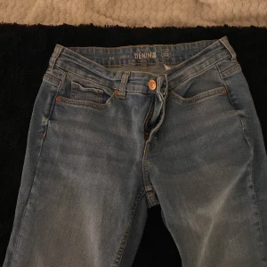 Blå jeansbyxor från Denim - Säljer ett par klassiska blå jeansbyxor från Denim. De har en normal passform med dragkedja och knapp framtill. Byxorna har fem fickor och en snygg tvättad look. Perfekta för en avslappnad stil.