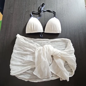 Bikini + sarong  - En helt ny vit bikini med mörkblå kanter - storlek 42. Fasta inlägg vilket är riktigt skönt, dem slipper åka runt. Plus en vit sarong som man kan knyta runt höften - stilrent och gulligt. Båda helt nya från H&M 🐬🐚🪸🌸🦩
