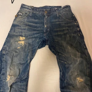  G-Star jeans - Snygga blå jeans från G-Star med slitna detaljer och en klassisk femficksdesign. Straight fit. Midja 42 cm längd 100cm benöpning 20 cm