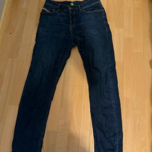Mörkblå jeans från Diesel - Snygga mörkblå jeans från Diesel. Modellen har rak passform och normal midja, med läderpatch baktill med Diesel-logga. Perfekta för dig som gillar stilrena och tidlösa jeans. Använda men i utmärkt skick! Pris är inte hugget i sten