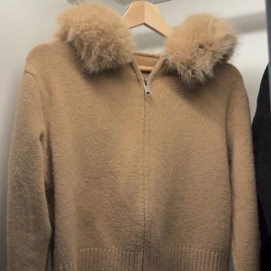 Beige teddyjacka med pälskrage - Supermysig beige teddyjacka med fluffig pälskrage och dragkedja framtill. Jackan har ribbade muddar och nederkant, samt långärmad passform. Perfekt för kyliga dagar när du vill vara både varm och snygg. (oanvänd) TRENDIG JACKA!! 🤌🏽🤌🏽
