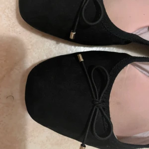 Svarta ballerina skor med rosett - Jättesöta ballerina skor med rosetter. Har tagit på mig de ett par gånger men de är fortfarande i bra skick. 